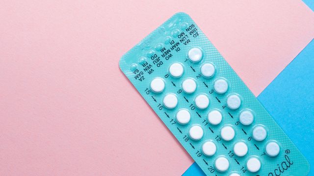 A packet of contraceptive pills on a pink and blue background. 