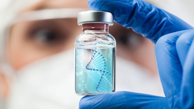 A lab working holding a glass vial that contains clear fluid and the DNA double helix. 