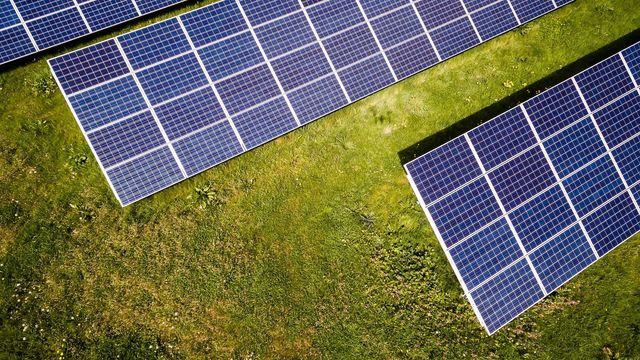 A top-down view of solar panels on grass. 