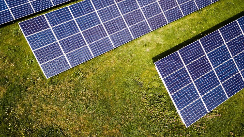 A top-down view of solar panels on grass.