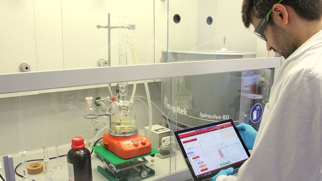 A scientist looking at an iPad in a laboratory. 