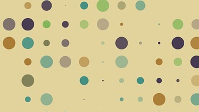 Purple, blue, yellow, green and grey dots on a yellow background representing a microarray. 