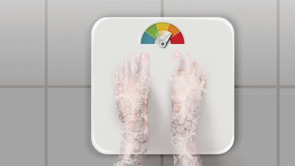 A person looking down at their feet on a weighing scale. 